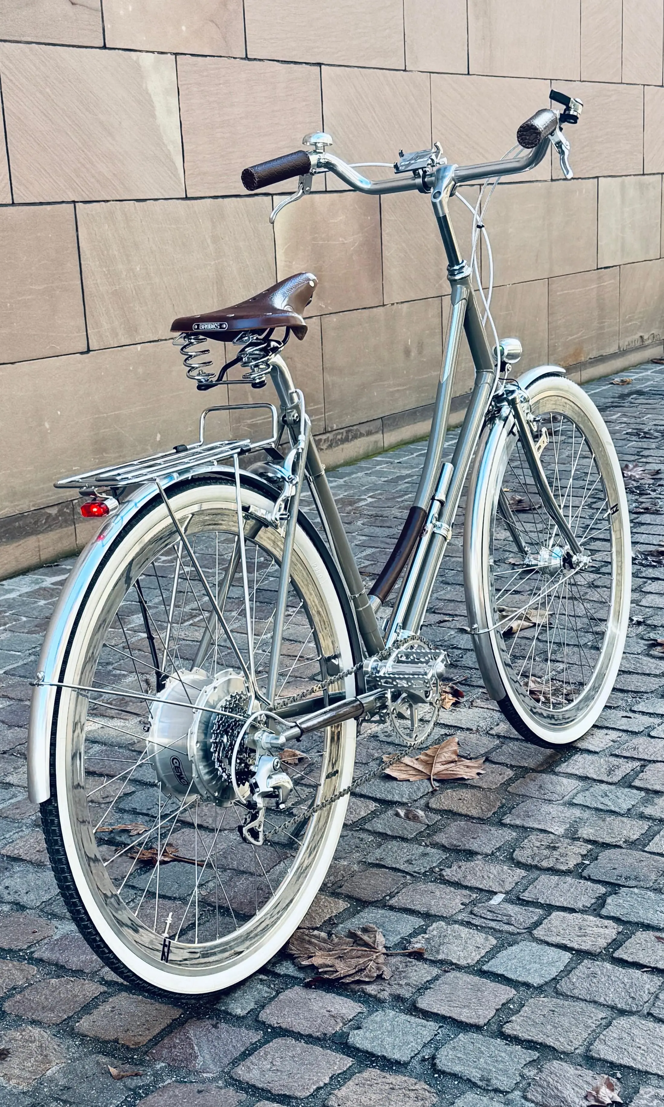 Silbernes Stahlvelo mit Ledersattel und Gepäckträger, im Hinterrad der Zehus-Nabenmotor, ein Umbau aus unserer Werkstatt